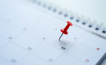 Image of a calendar with a red push pin